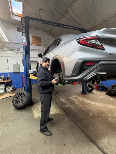 Technician performing brake service on a Subaru WRX