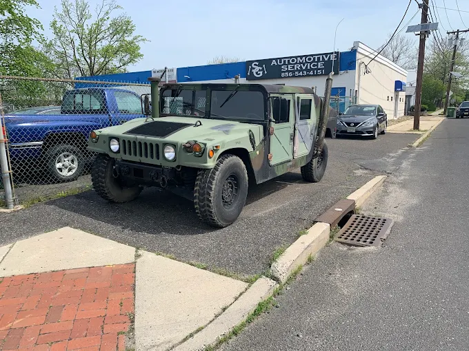 Green military Humvee parked outside SG Automotive shop